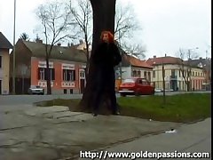 Grown-up redhead taking a piss wide a public park